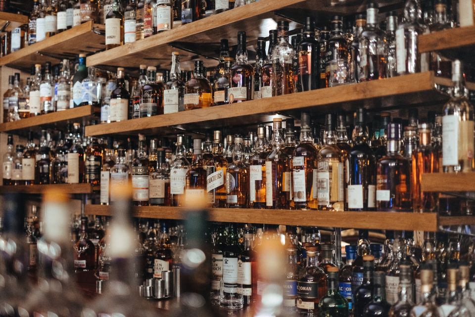 A Lot Of Alcohol Bottles Arranged On Shelves